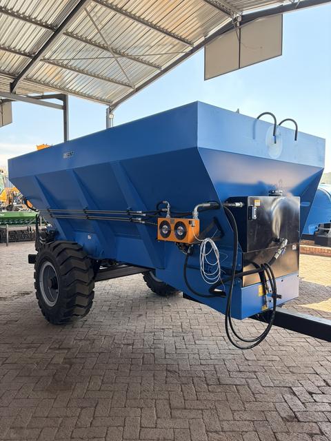 Giant hydraulic manure spreader, side view showing the hydraulic hoses and the control valves on the hopper wall