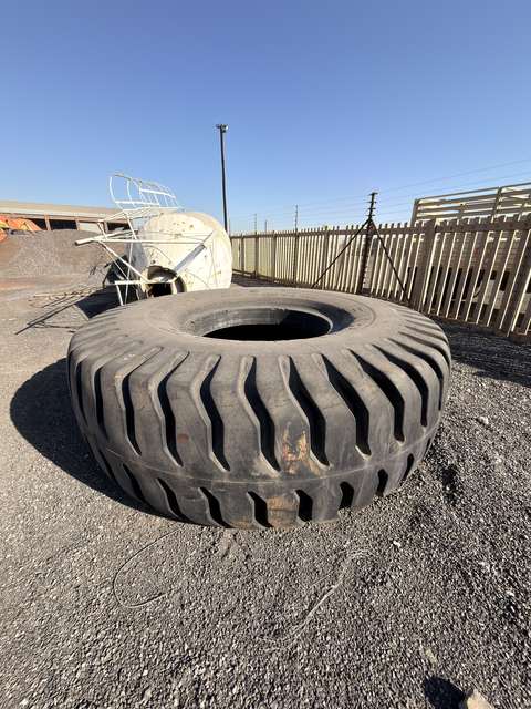 Single earthmover tyre lying on the gravel, angled view of the tread