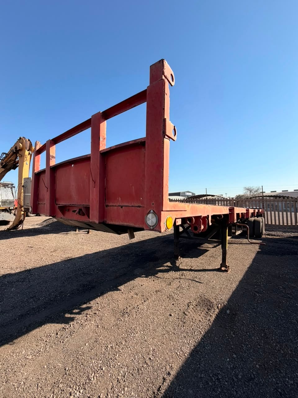 Used 12m flat deck trailer, three-quarter view along the full deck to the stanchion headboard