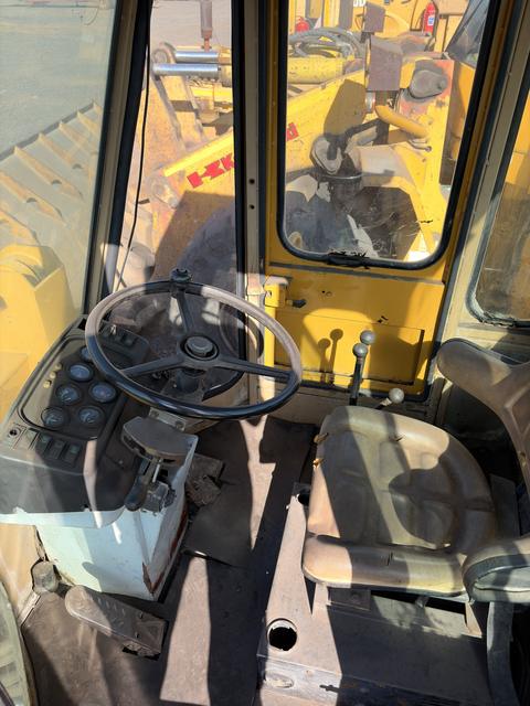 Inside the cab of the used Fugong front end loader, steering wheel, levers and seat