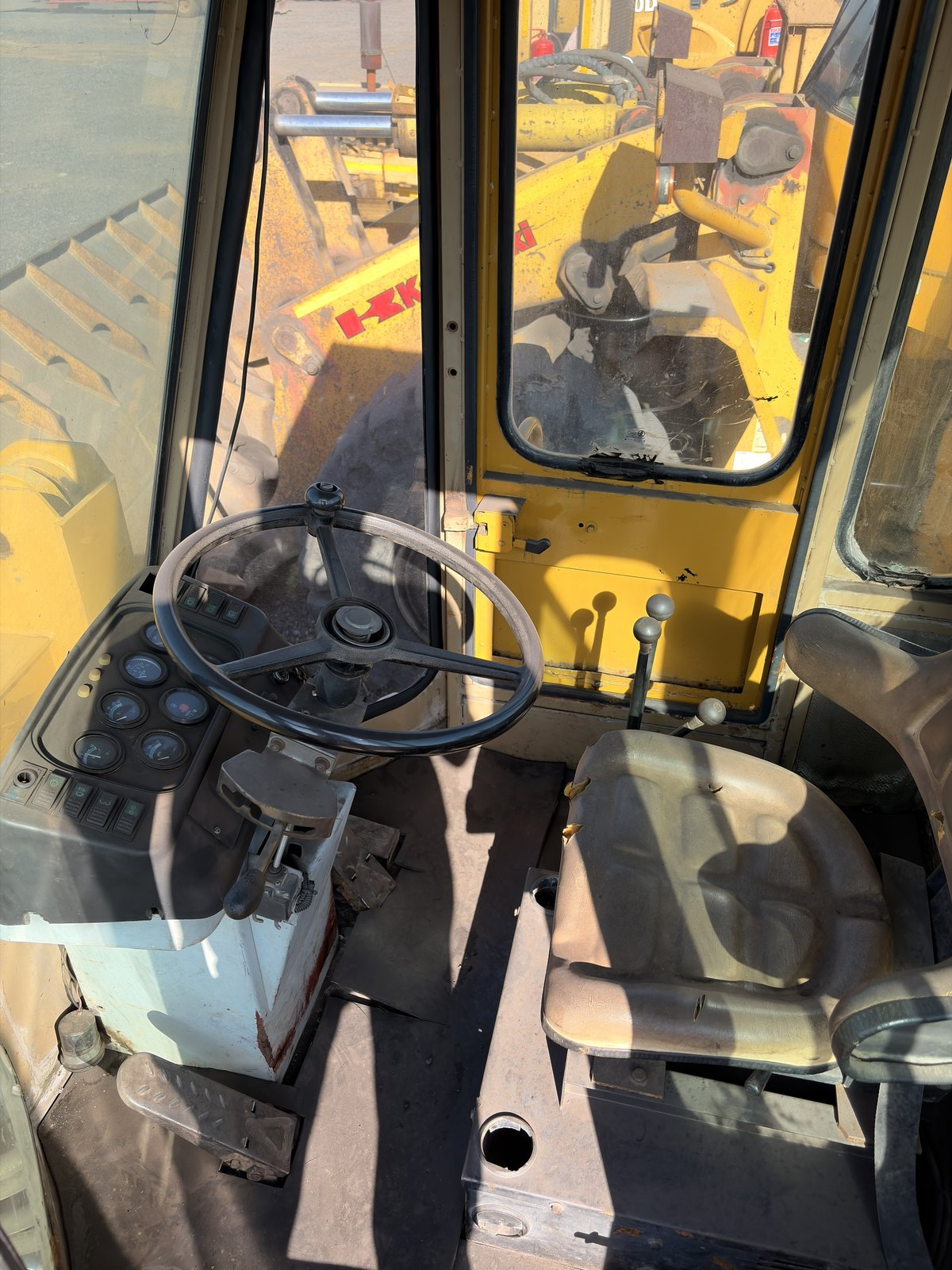Inside the cab of the used Fugong front end loader, steering wheel, levers and seat