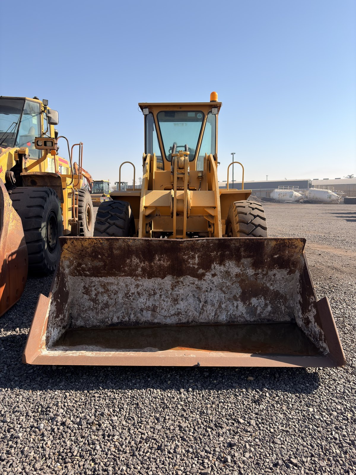 Used Fugong front end loader, head-on view with the bucket flat on the ground