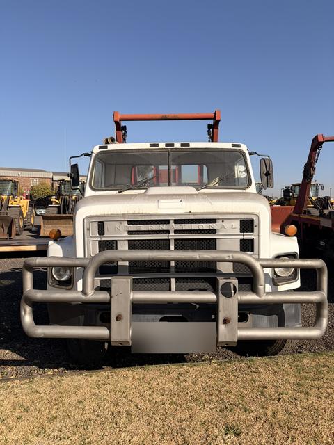 Used International skip loader truck, head-on view of the grille and cab