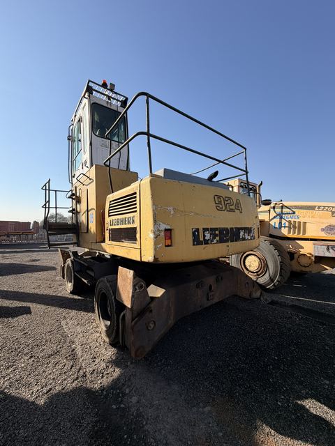 Used Liebherr 924 material handler, rear-quarter view with a wheel loader behind it