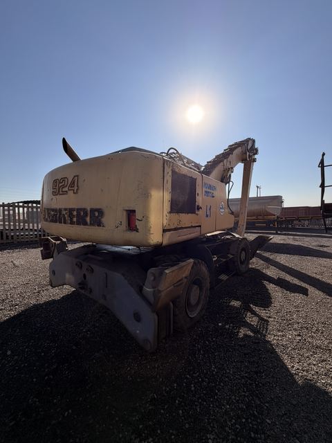 Used Liebherr 924 material handler, rear view shot into the sun