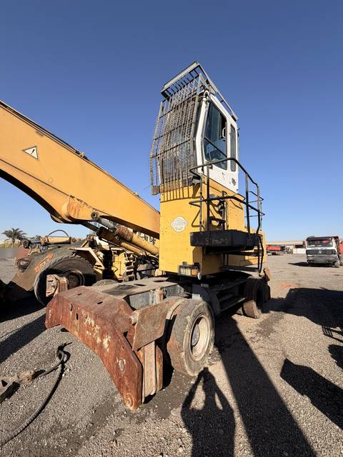 Used Liebherr 924 material handler, front three-quarter view with the boom folded over the cab
