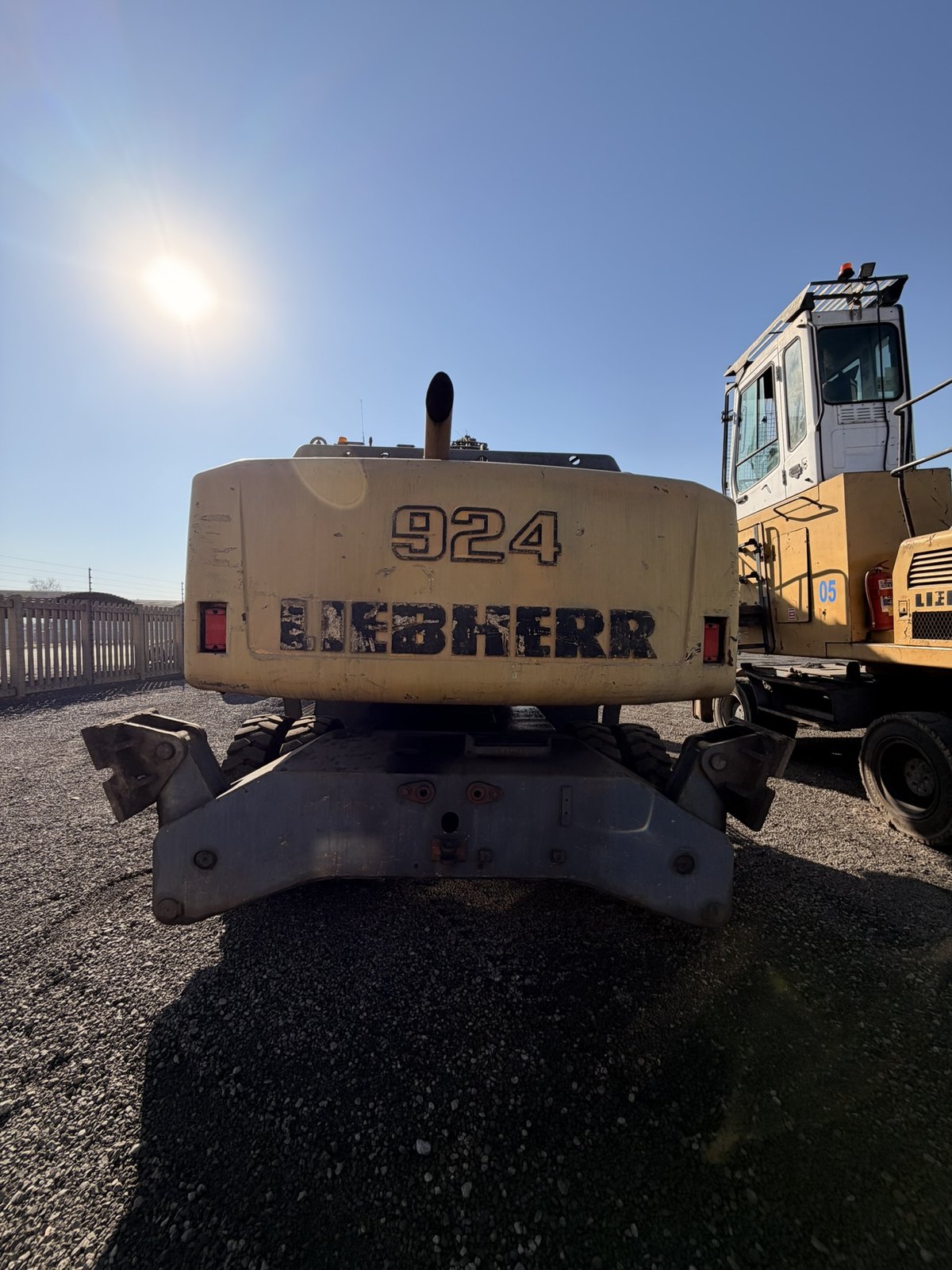 Used Liebherr 924 material handler, rear-on view of the counterweight, a second machine standing alongside