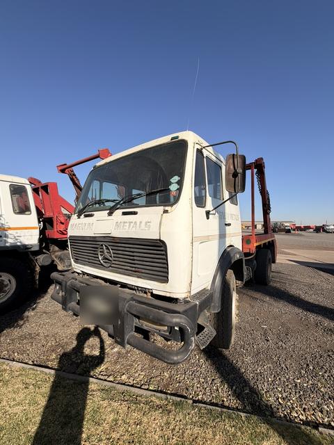 Used Mercedes skip loader truck, front three-quarter view with the skip-loading gear behind the cab