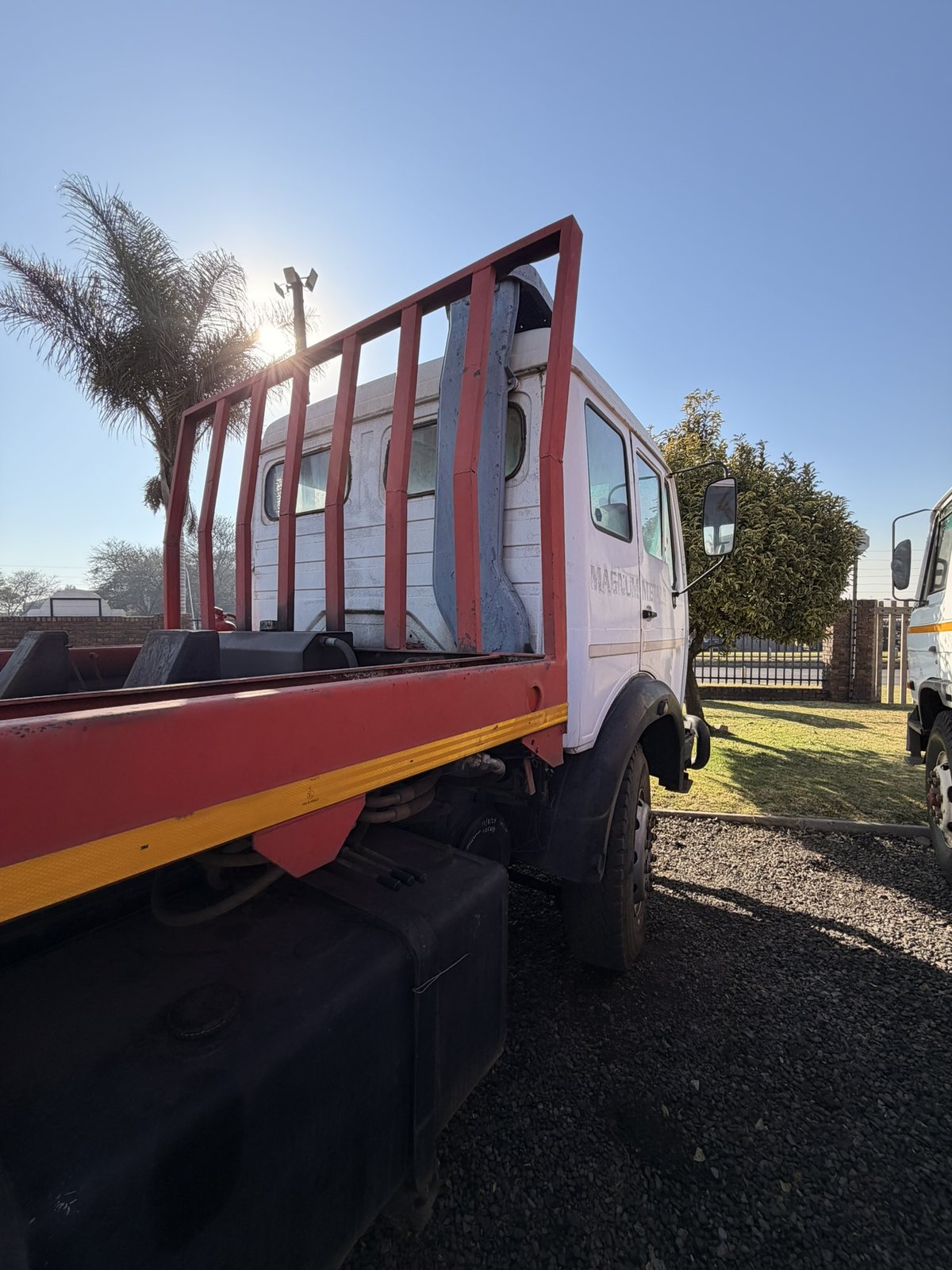 Used Mercedes skip loader truck, side view of the cab and dropside body