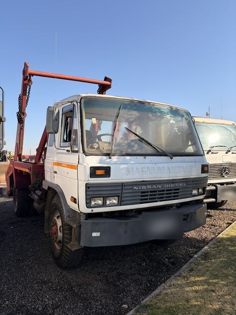 Used Nissan Diesel skip loader truck, front three-quarter view of the cab and skip-loading gear