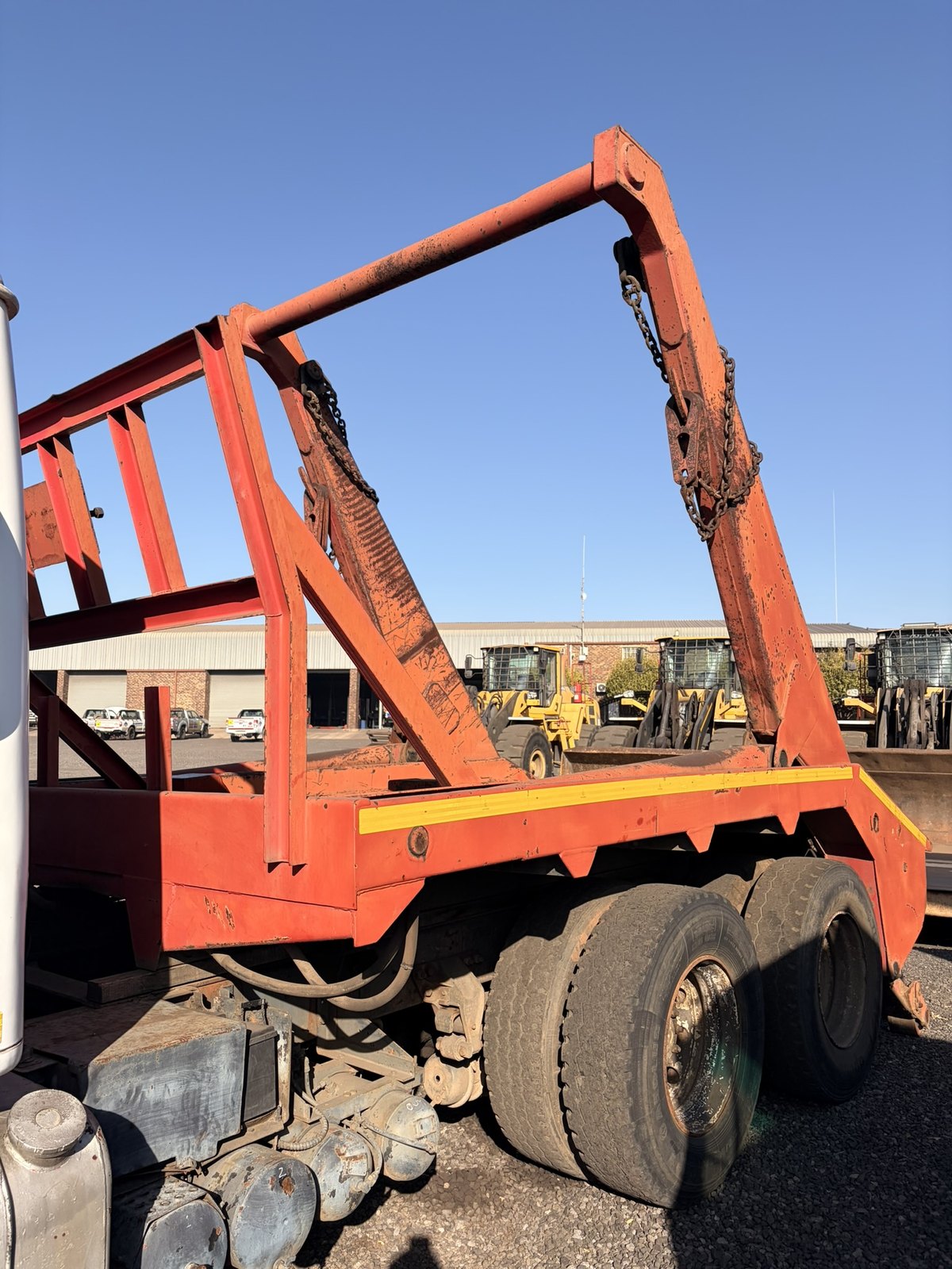 Skip loader truck in the consignment yard, close view of the rear skip frame and drive axles