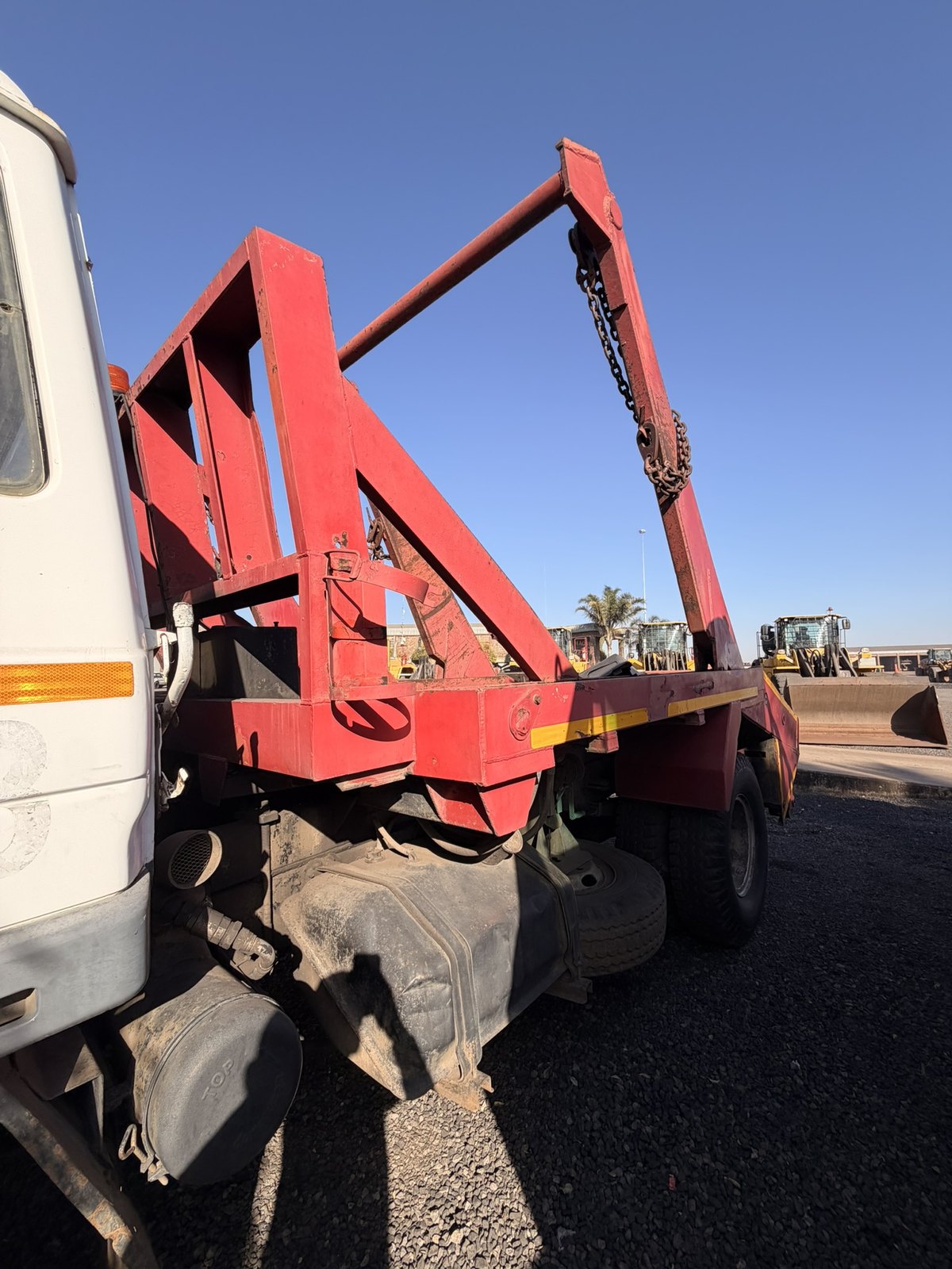 Used Nissan Diesel skip loader truck, side view of the skip arms above the deck