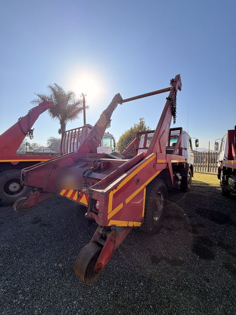 Used Nissan Diesel skip loader truck, rear view of the deck and lifting chains