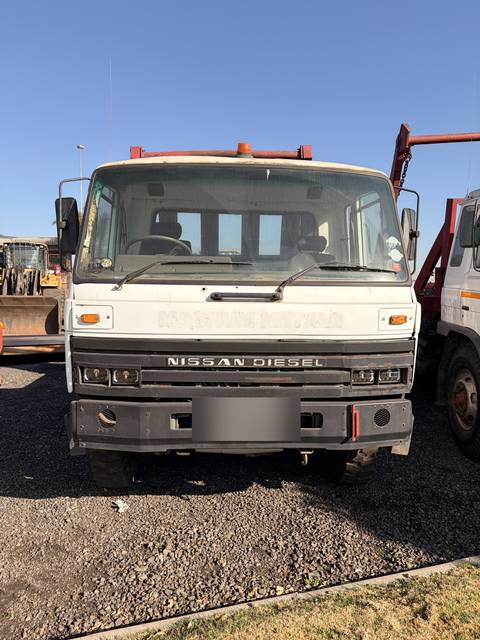 Second used Nissan Diesel skip loader truck, head-on view of the grille and cab