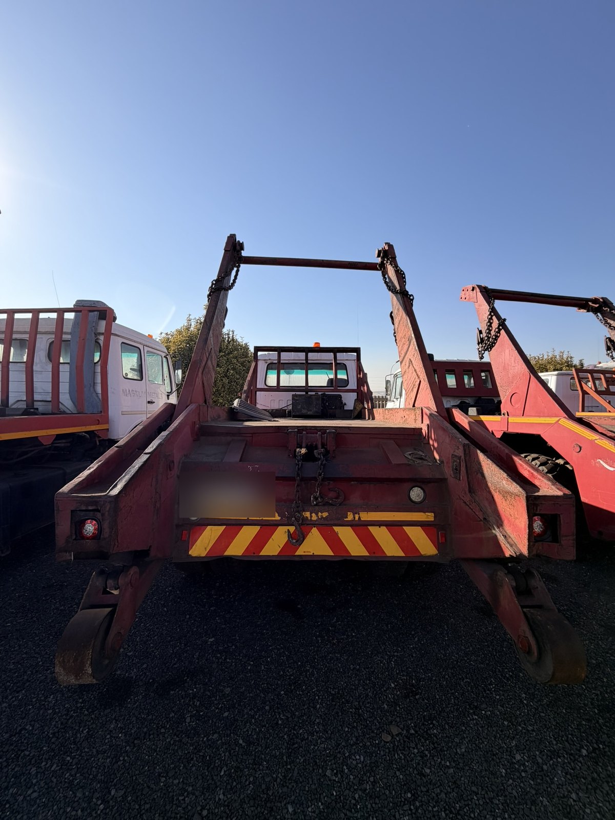 Used Nissan Diesel skip loader truck, rear view of the deck and skip-loading gear
