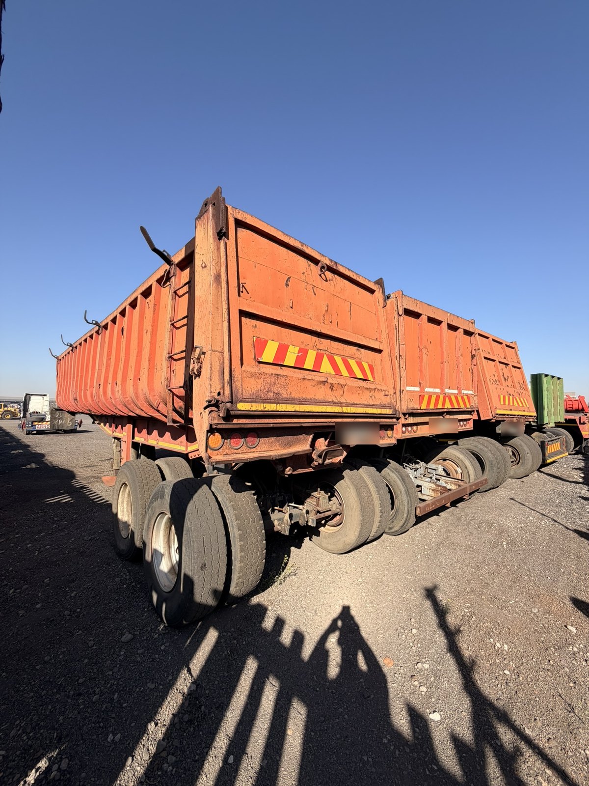 Coupled tipper trailers, side view showing the drawbar dollies between the bodies