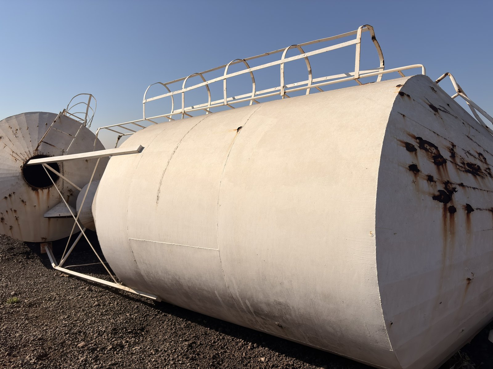 Used storage silo lying on its side, three-quarter view with the ladder and caged top