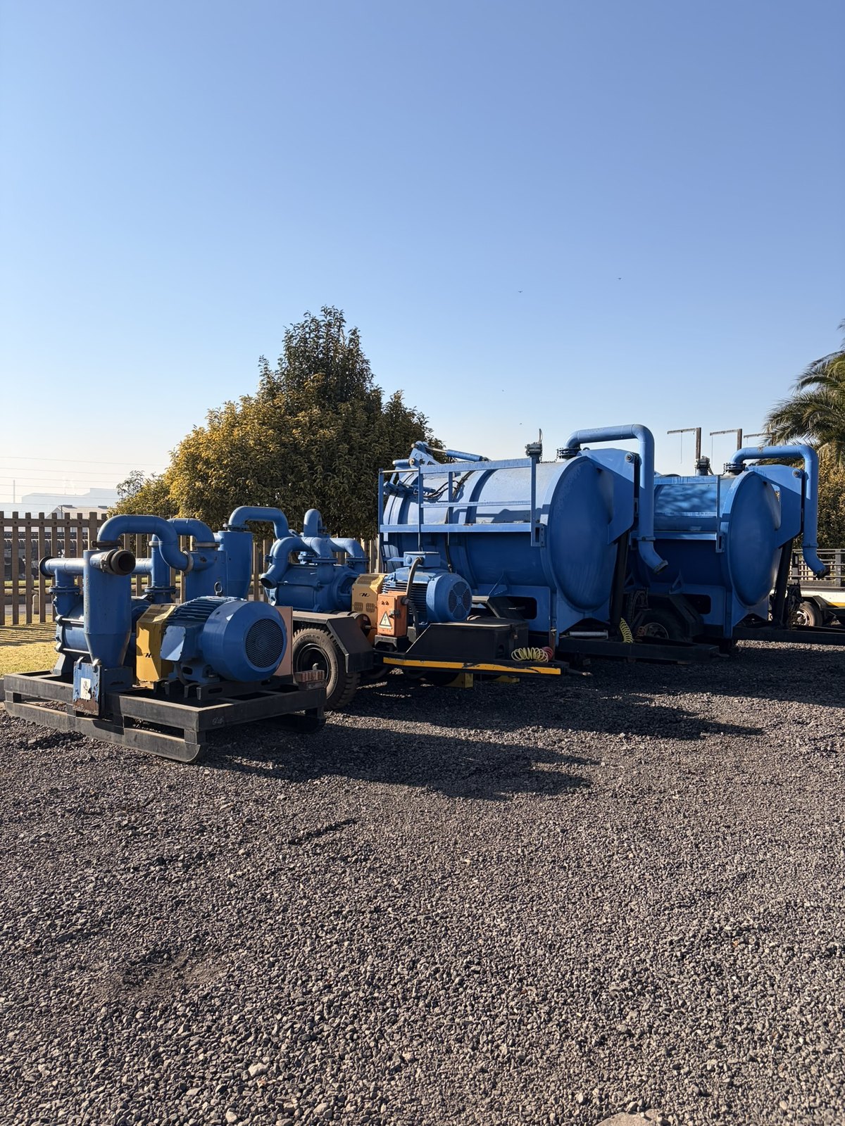 The slurry pump lot seen along the yard apron, pumps in front and the blue vacuum tankers behind