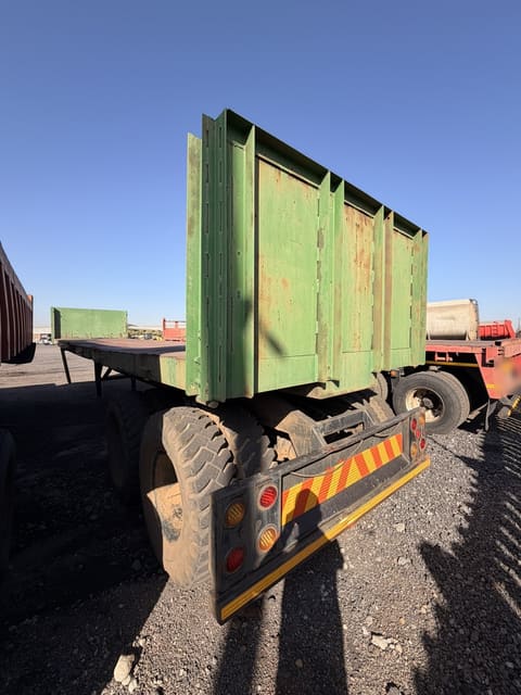 Used 12m trailer with high steel sides, rear three-quarter view showing the high steel sides and tandem axles