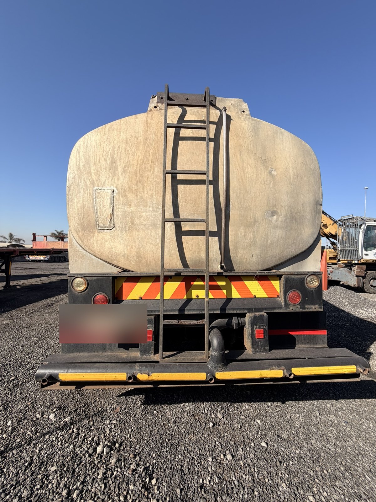 Used water tanker, rear view of the tank, ladder and rear bumper